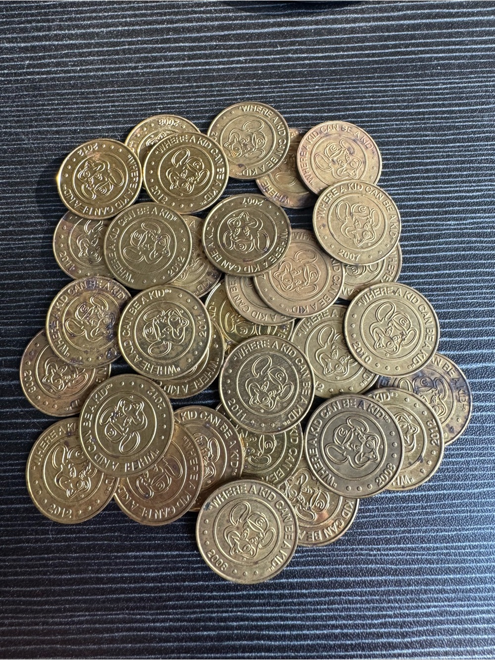 Vintage 32 Brass Chuck E Cheese Tokens. Years range from 2003-2012